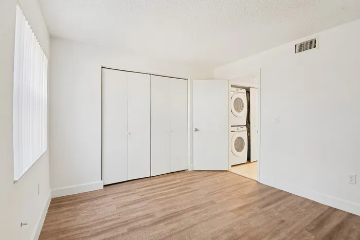 Bright and airy room with wood flooring and in-unit laundry facilities, offering a perfect blend of comfort and convenience.