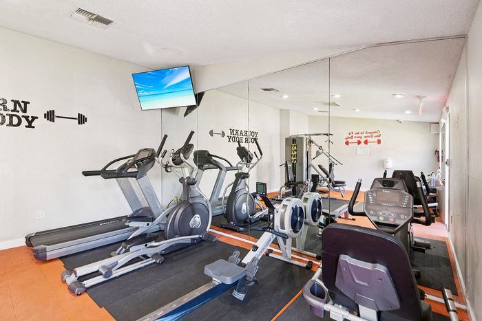 Modern fitness center with sleek exercise equipment, mirrored walls, and motivational decor for an inspiring workout experience.