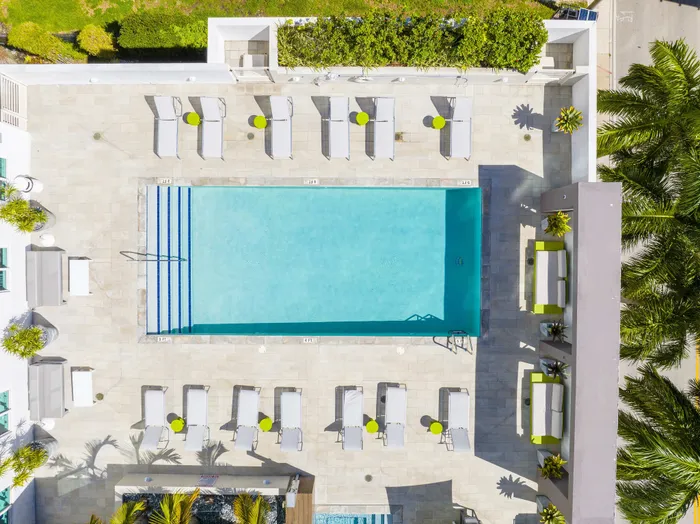 Luxurious rooftop pool area with modern lounge chairs, chic cabanas, and vibrant greenery creating an inviting escape.