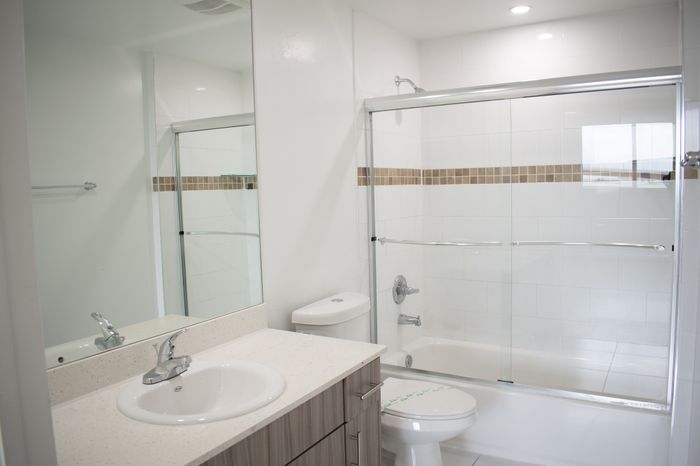 Modern bathroom with a sleek glass shower enclosure, stylish vanity with quartz countertop, and elegant tile accents.