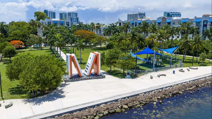 Scenic waterfront park with vibrant greenery, modern architectural features, and inviting walking paths.