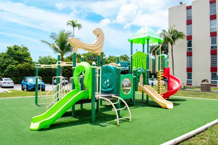 Vibrant playground with colorful slides and climbing structures, surrounded by lush greenery, perfect for family fun and outdoor enjoyment.