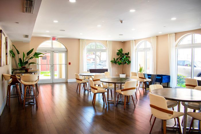 Bright and welcoming communal lounge with stylish seating, modern decor, and large arched windows providing natural light.