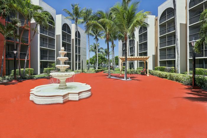 Vibrant courtyard featuring a stunning water fountain surrounded by tropical palm trees and elegant apartment buildings.