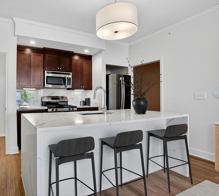 Luxury Kitchen with Gas Stove and Waterfall Quartz Countertops | Luxe at Union Hill | Kansas City, MO Apartments