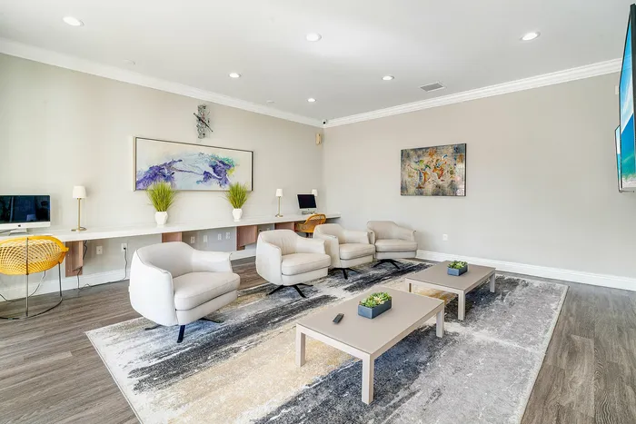 Contemporary lounge with elegant armchairs, modern artwork, and natural light, perfect for relaxation and productivity.