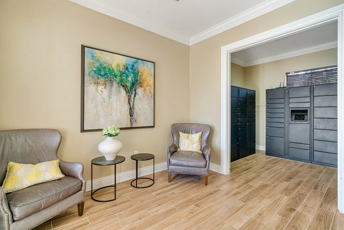 Inviting lounge area featuring elegant armchairs, a vibrant abstract painting, and sophisticated decor, perfect for relaxation.