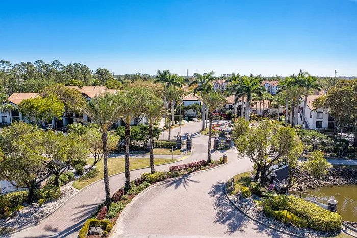 Lush apartment community featuring palm-lined pathways, stunning landscaping, and elegant architecture under a clear blue sky.