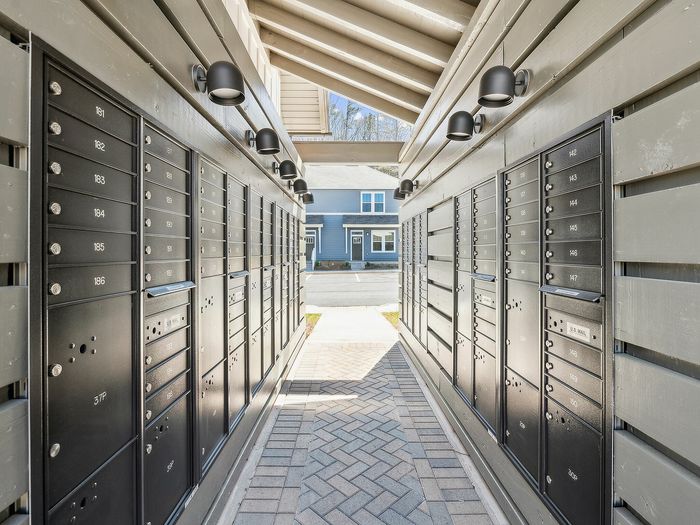 Modern apartment mail center with sleek black mailboxes and contemporary lighting, creating a welcoming and secure entrance.