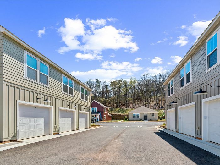 Inviting residential complex with modern garages and clean architectural design under a clear blue sky.
