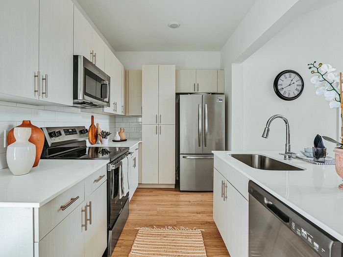 Modern kitchen with sleek stainless steel appliances, elegant white cabinetry, and a stylish open layout.