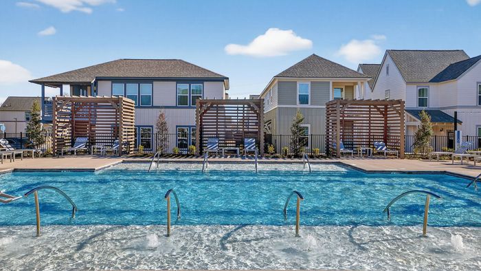 Elegant apartment complex featuring a large, inviting swimming pool with stylish wooden pergolas and comfortable lounge chairs for relaxation.