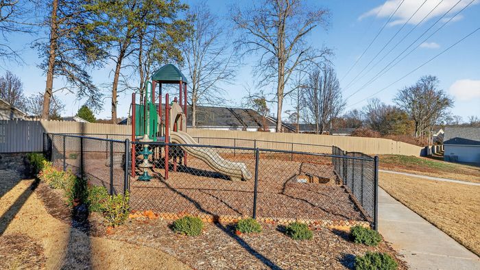 Charming playground with slides in a landscaped community setting, perfect for family fun.