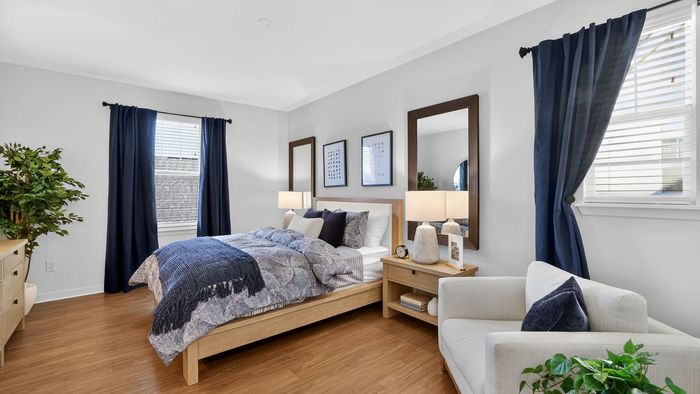 Chic and cozy bedroom featuring elegant decor, plush bedding, and abundant natural light with stylish blue accents.