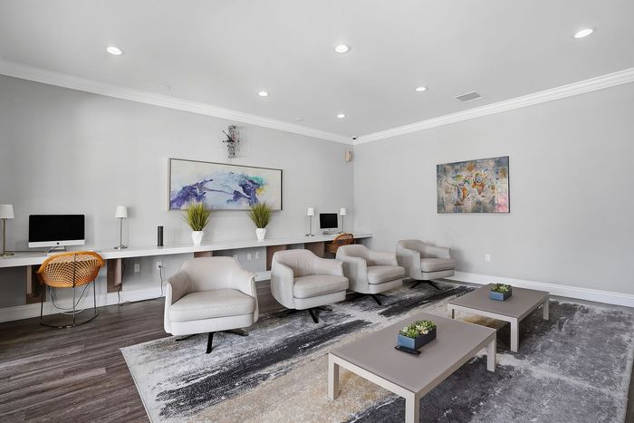 Modern community lounge with stylish seating, sleek workstations, and vibrant artwork, perfect for relaxation and productivity.