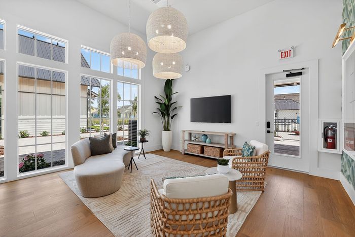 Bright, modern living room with large windows, elegant lighting, and stylish seating offering a welcoming retreat.