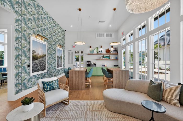 Bright and modern apartment lounge with chic decor, natural light streaming through large windows, and stylish seating areas.