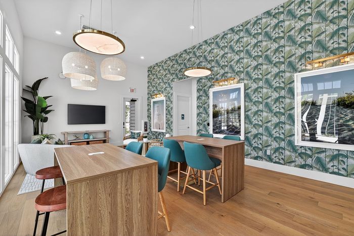 Elegant living space with vibrant tropical wallpaper, stylish pendant lighting, and modern furniture.