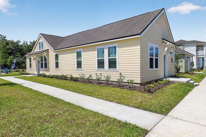 Charming yellow single-story home with manicured landscaping and a welcoming front path.