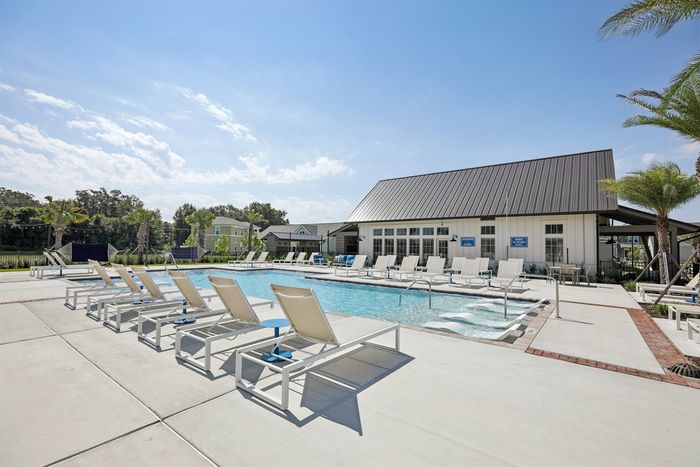 Inviting community pool area with stylish lounge chairs and lush landscaping for a relaxing outdoor experience.