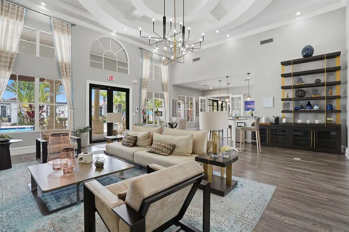 Elegant and spacious living area with high ceilings, modern chandeliers, stylish furniture, and a cozy ambiance.
