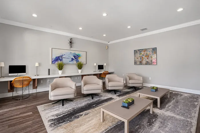 Elegant and modern shared workspace with comfortable seating, stylish artwork, and sleek workstations.