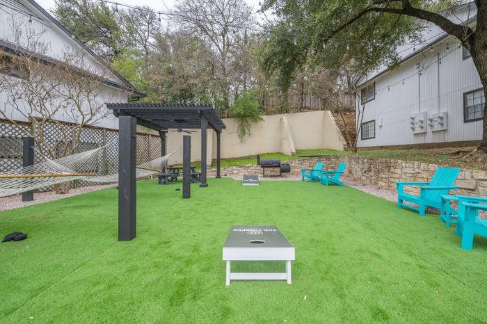 Outdoor social area with lawn games, seating, landscaping  at The Timbers apartments
