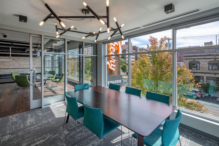 Conference table in clubhouse with glass walls at  Theory Syracuse | NY Apartments for Students