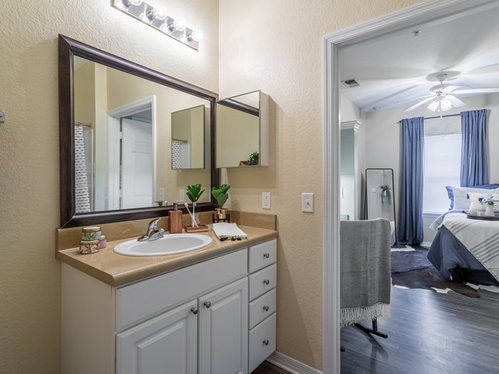 Bathroom with vanity mirror and cabinetry | Shower and tub visible | Hawks Landing | Apartments in Tampa, FL