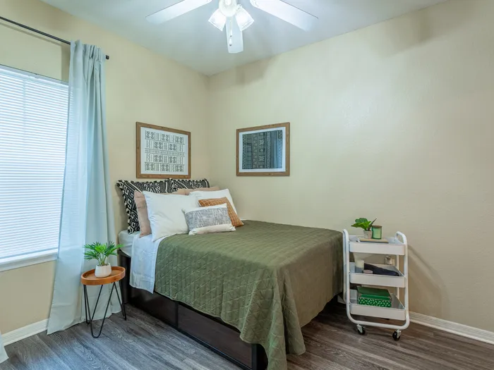 Charming bedroom view | Sizable bed | Draping curtains |  Ceiling fan | Hawks Landing | Apartments in Tampa, FL