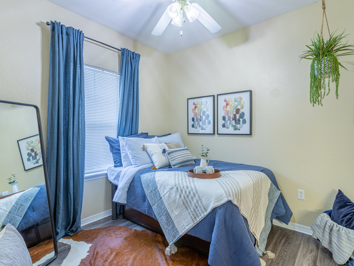Charming bedroom view | Sizable bed | Draping curtains |  Ceiling fan | Hawks Landing | Apartments in Tampa, FL