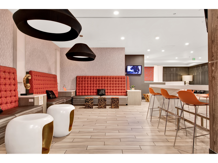 Striking pendant lighting, seating, and computer bar in common area | University Gateway Apartments in Los Angeles, CA.