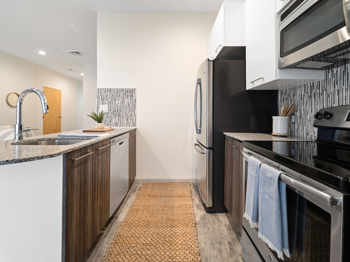 Galley-style kitchen with stainless steel appliances at The Printing House | Binghamton Apartments
