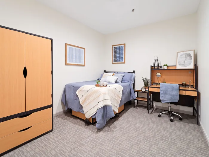 Bedroom with closet storage space and desk at The Printing House | Binghamton Apartments