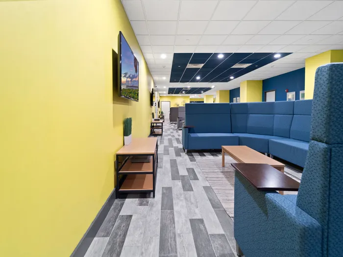 Seating and flat screen TV in clubhouse common area at The Printing House | Binghamton Apartments
