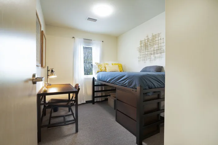 Bedroom with bed, storage, and desk at Tech Village | Student Apartments Appleton