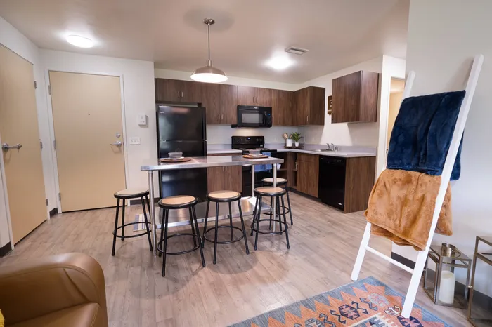 Kitchen with black appliances at student apartments at Tech Village.