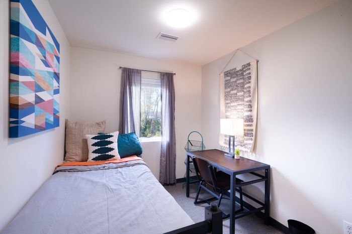 Bedroom with desk in student apartment at Tech Village.