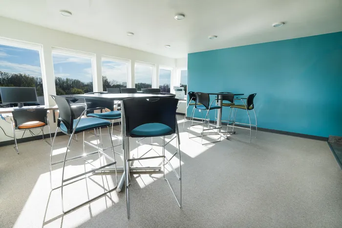 Common area with tables, chairs, computers at at Tech Village | Appleton Apartments
