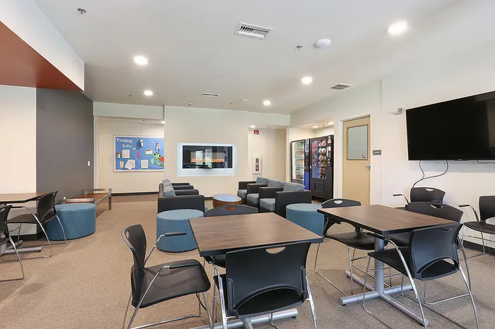 Clubhouse with seating, tables, & TV at Tech Village | Appleton Apartments
