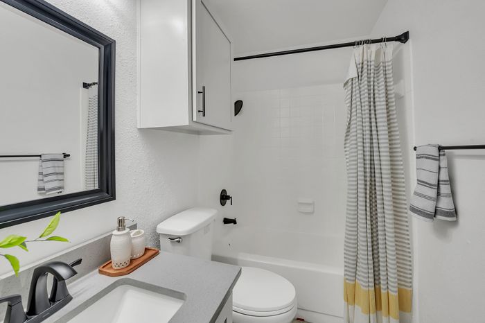 Contemporary bathroom with a modern vanity, chic mirror, and a clean shower space.