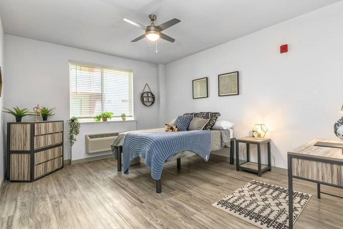 Bedroom - wood-plank flooring, ceiling fan, and spacious rooms in apartment at Merced Station.