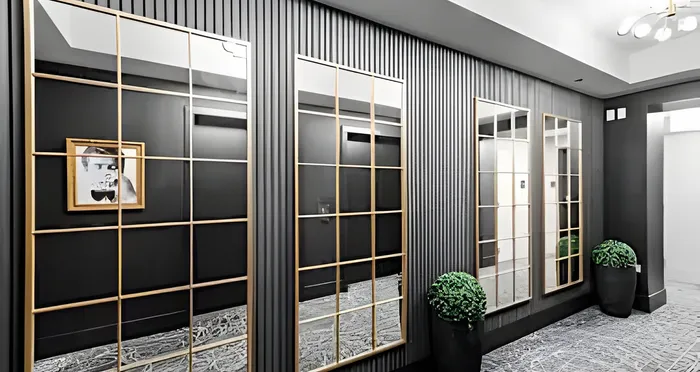 Elegant apartment hallway featuring modern mirrors and stylish wall accents with lush potted plants, creating a sophisticated and inviting atmosphere.