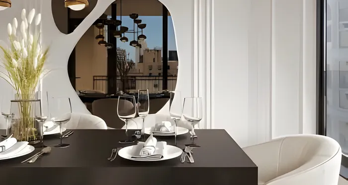Modern dining area with elegant black table set for a meal, featuring white chairs and a decorative vase with greenery, enhanced by a large window view.