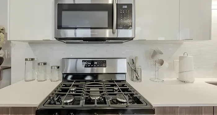 Modern kitchen with sleek stainless steel appliances, elegant white cabinetry, and a polished countertop, perfect for culinary enthusiasts.
