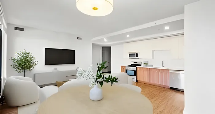 Bright and modern open-concept living room and kitchen with sleek appliances and stylish decor.