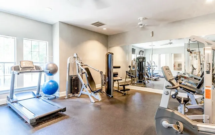 Bright and modern gym with state-of-the-art workout equipment, including treadmills, exercise bikes, and strength machines.
