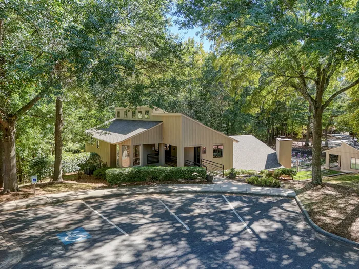 Charming residential building nestled among lush green trees, offering a peaceful and inviting atmosphere.