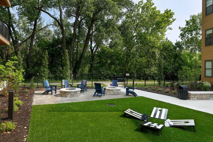 Cozy firepit and yard games area in the courtyard of Wheatfield Village Apartments, Topeka, KS.