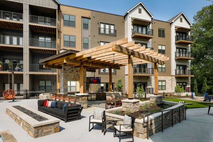 Relaxing outdoor seating at the Grilling Lounge in Wheatfield Village Apartments, Topeka, KS. Enjoy the amenities of a TV, fire pits, ice machine, and beverage fridge.